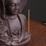 bâtonnet d'encens vertical posé sur porte-encens bouddha
